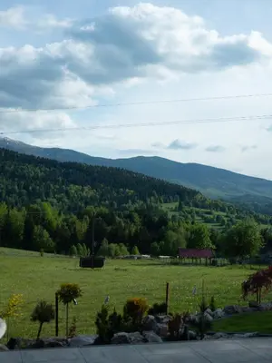 a field of grass with mountains in the background at Babiogórska Stodoła in Zawoja