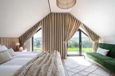 a bedroom with a large bed and a green couch at Osada Tabaszowa in Tabaszowa