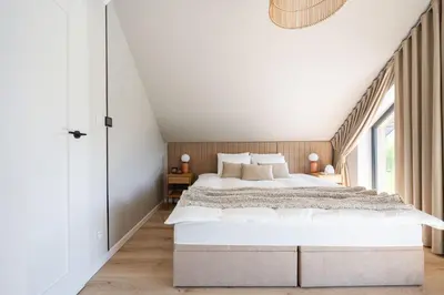 a bedroom with a large bed and a large window at Osada Tabaszowa in Tabaszowa