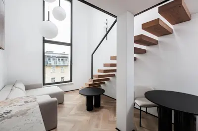 a living room with stairs and a table at City of the Kings-Riverside K22M52 in Kraków