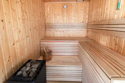 a wooden sauna with a bench in the middle at Noble Apartment & Sauna ZONE in Zabierzów
