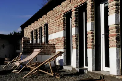two folding chairs sitting outside of a brick building at Noble Apartment & Sauna ZONE in Zabierzów