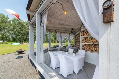 a patio with white chairs and a table on a building at Noble Apartment & Sauna ZONE in Zabierzów