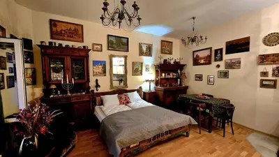 a bedroom with a bed and a table and a chandelier at ATELIER Kazimierz in Kraków