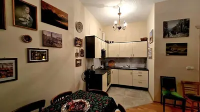 a kitchen with white cabinets and a table in a room at ATELIER Kazimierz in Kraków