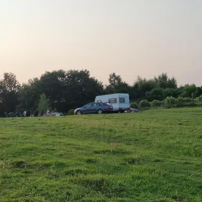a car parked in a field next to a trailer at Uszate Ranczo in Rybna