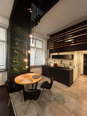 a kitchen with a wooden table and chairs and a kitchen with a counter at Vintage Bracka Loft Apartment in Kraków
