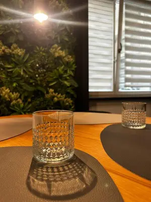 a glass sitting on top of a wooden table at Vintage Bracka Loft Apartment in Kraków