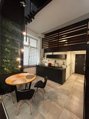 a kitchen with a table and some chairs and a table and a kitchen at Vintage Bracka Loft Apartment in Kraków