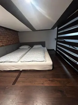 a large bed in a room with a brick wall at Vintage Bracka Loft Apartment in Kraków