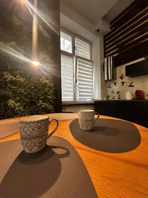 two cups sitting on top of a wooden table at Vintage Bracka Loft Apartment in Kraków