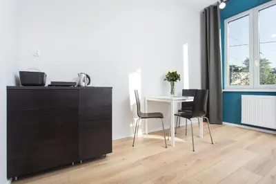 a dining room with a table and chairs and a dresser at Krakow B&B in Kraków