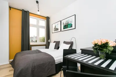 a bedroom with a bed and a bench with flowers at Krakow B&B in Kraków