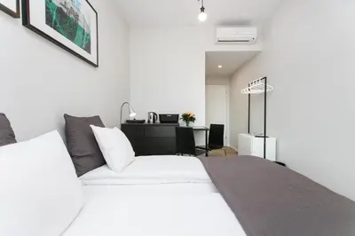 a bedroom with a white bed and a desk at Krakow B&B in Kraków
