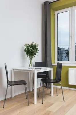 a table and chairs with a vase of flowers on it at Krakow B&B in Kraków
