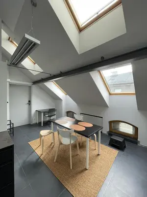 a room with a table and chairs and a skylight at Atelier Stare Miasto in Chrzanów