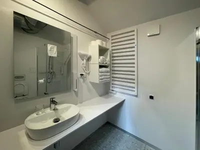 a white bathroom with a sink and a mirror at Atelier Stare Miasto in Chrzanów