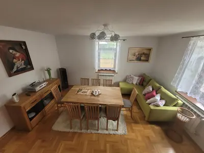 a living room with a table and a green couch at Domek obok pustyni
