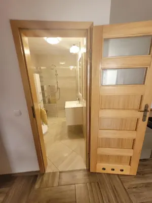 a bathroom with a shower and a sliding door at Domek obok pustyni