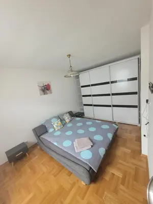 a bedroom with a bed and a wooden floor at Domek obok pustyni