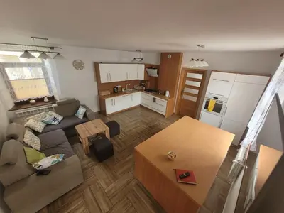 a living room with a couch and a table and a kitchen at Domek obok pustyni