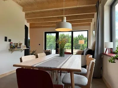 a dining room with a wooden table and chairs at BeskiDom in Zawoja