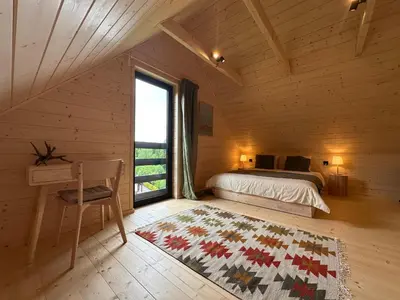 a bedroom with a bed and a desk and a window at BeskiDom in Zawoja