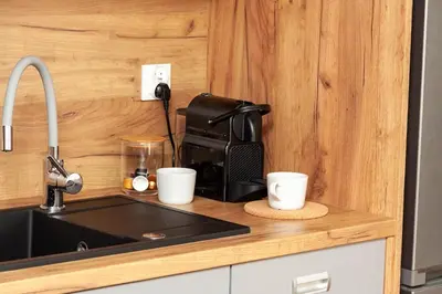 a kitchen counter with a coffee maker and cups at Apartament Bonarka in Kraków