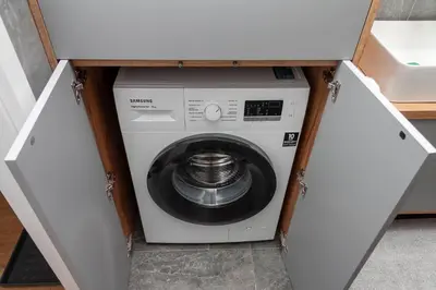 a washer and dryer in a cabinet in a kitchen at Apartament Bonarka in Kraków