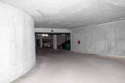 an empty garage with a car parked in it at Apartament Bonarka in Kraków