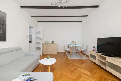 a living room with a couch and a tv and a table at Prusa Stylish Apartment Close to the Center of Cracow by Noclegi Renters in Kraków