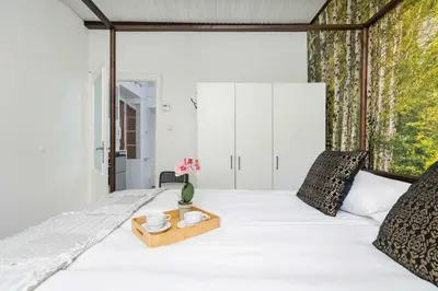 a bedroom with a white bed with a wooden tray on it at Prusa Stylish Apartment Close to the Center of Cracow by Noclegi Renters in Kraków