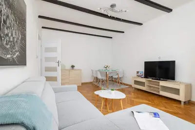 a living room with a couch and a tv at Prusa Stylish Apartment Close to the Center of Cracow by Noclegi Renters in Kraków
