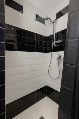 a bathroom with a shower with black and white tiles at Prusa Stylish Apartment Close to the Center of Cracow by Noclegi Renters in Kraków