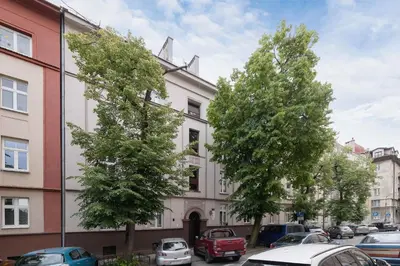 two trees in front of a building with cars parked at Prusa Stylish Apartment Close to the Center of Cracow by Noclegi Renters in Kraków