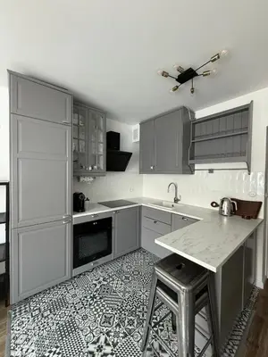 a kitchen with white cabinets and a table in it at VINCI apartment in Kraków