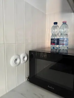 two bottles of water sitting on top of a microwave at VINCI apartment in Kraków