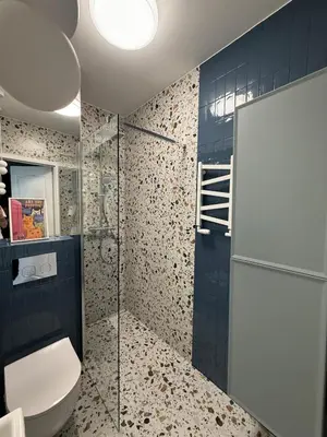 a bathroom with a toilet and a glass shower at VINCI apartment in Kraków