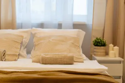 a bed with white sheets and pillows in a room at Osiedle Kazimierzowskie in Kraków