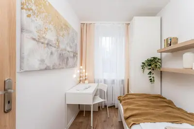 a small bedroom with a desk and a bed at Osiedle Kazimierzowskie in Kraków