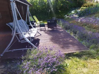 a wooden deck with chairs and a swing at Lavender Retreat in Kraków