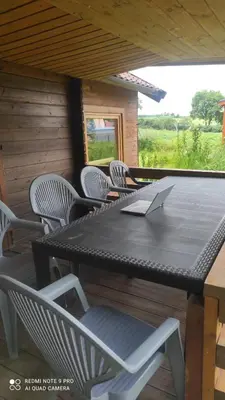 a table and chairs on a porch with a laptop at Lavender Retreat in Kraków
