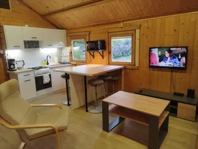 a kitchen with a table and a tv in a cabin at Lavender Retreat in Kraków