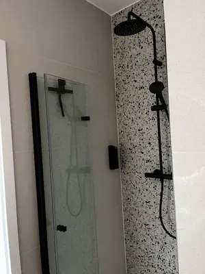 a shower in a bathroom with a glass shower backdoor at Apartamenty Rubikon in Kraków
