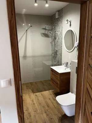 a bathroom with a toilet and a sink and a mirror at Apartamenty Rubikon in Kraków