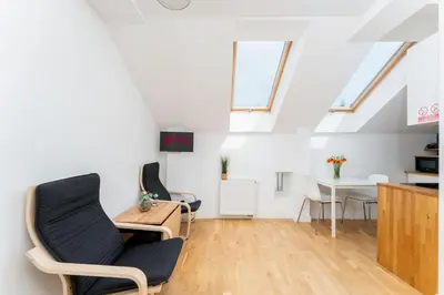 a room with a table and chairs in a attic at Malila Premium Apartments Cracow Prażmowskiego 46 in Kraków