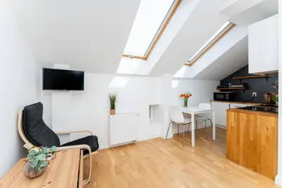 a kitchen and living room with a table and chairs at Malila Premium Apartments Cracow Prażmowskiego 46 in Kraków