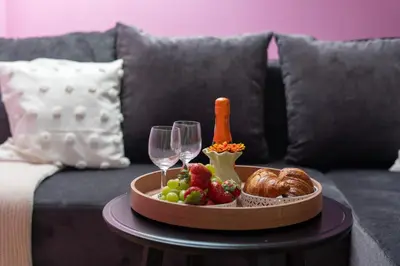 a tray of food and wine on a table on a couch at Malila Premium Apartments Cracow Prażmowskiego 46 in Kraków