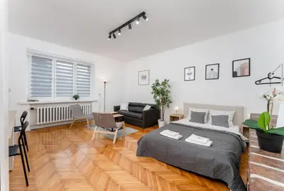 a bedroom with a bed and a living room at Zabłocie Comfort House with parking and garden in Kraków