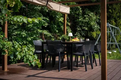 a table and chairs on a deck with an umbrella at Zabłocie Comfort House with parking and garden in Kraków